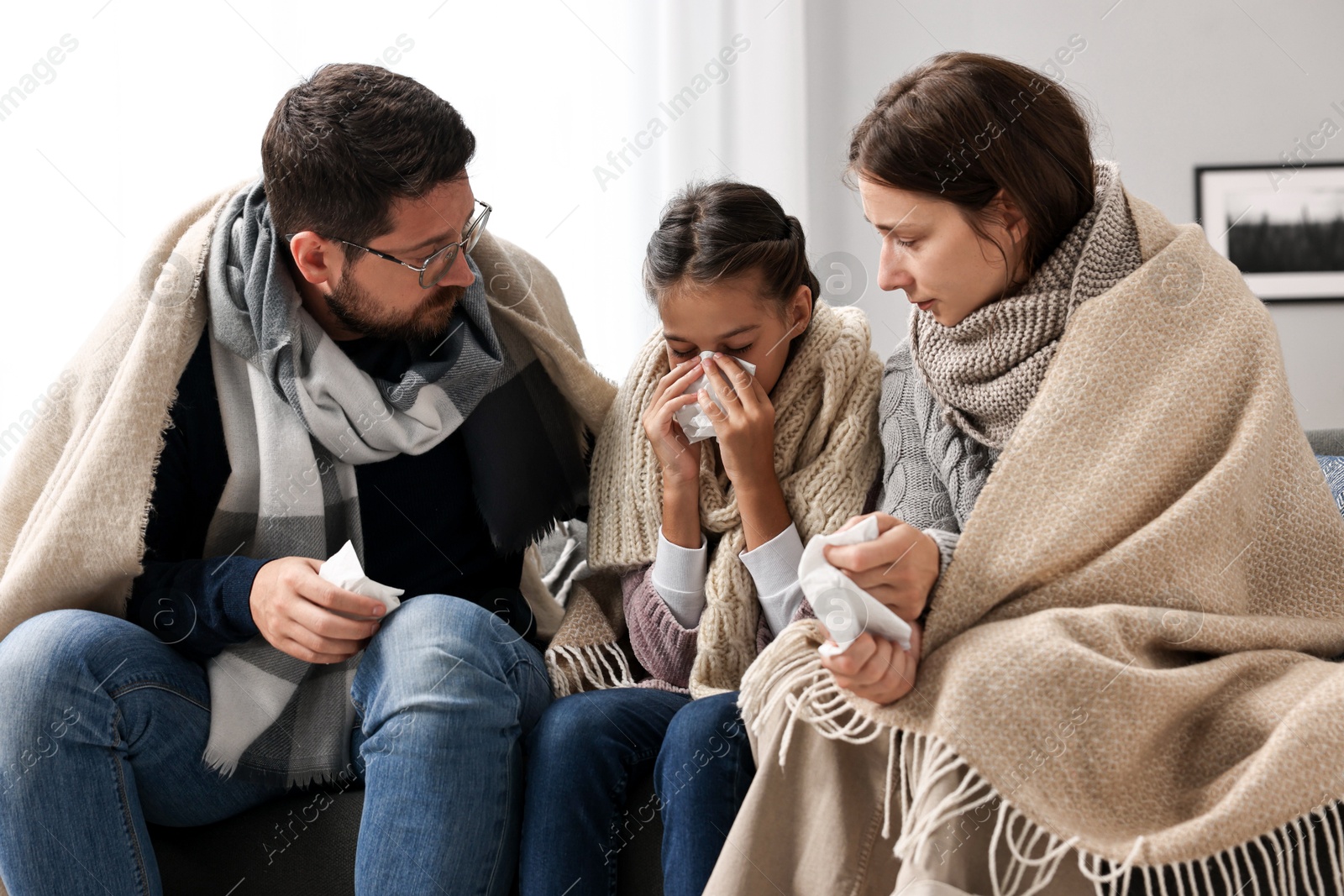 Photo of Cold symptom. Family suffering from fever on sofa at home