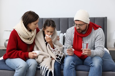 Cold symptom. Family suffering from fever on bed at home