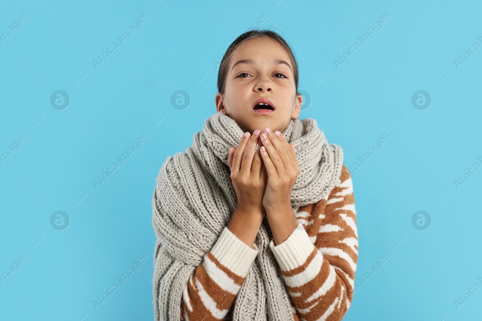 Photo of Cold symptom. Little girl suffering from fever on light blue background