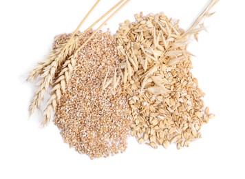 Raw wheat groats, oat flakes and spikelets isolated on white, top view