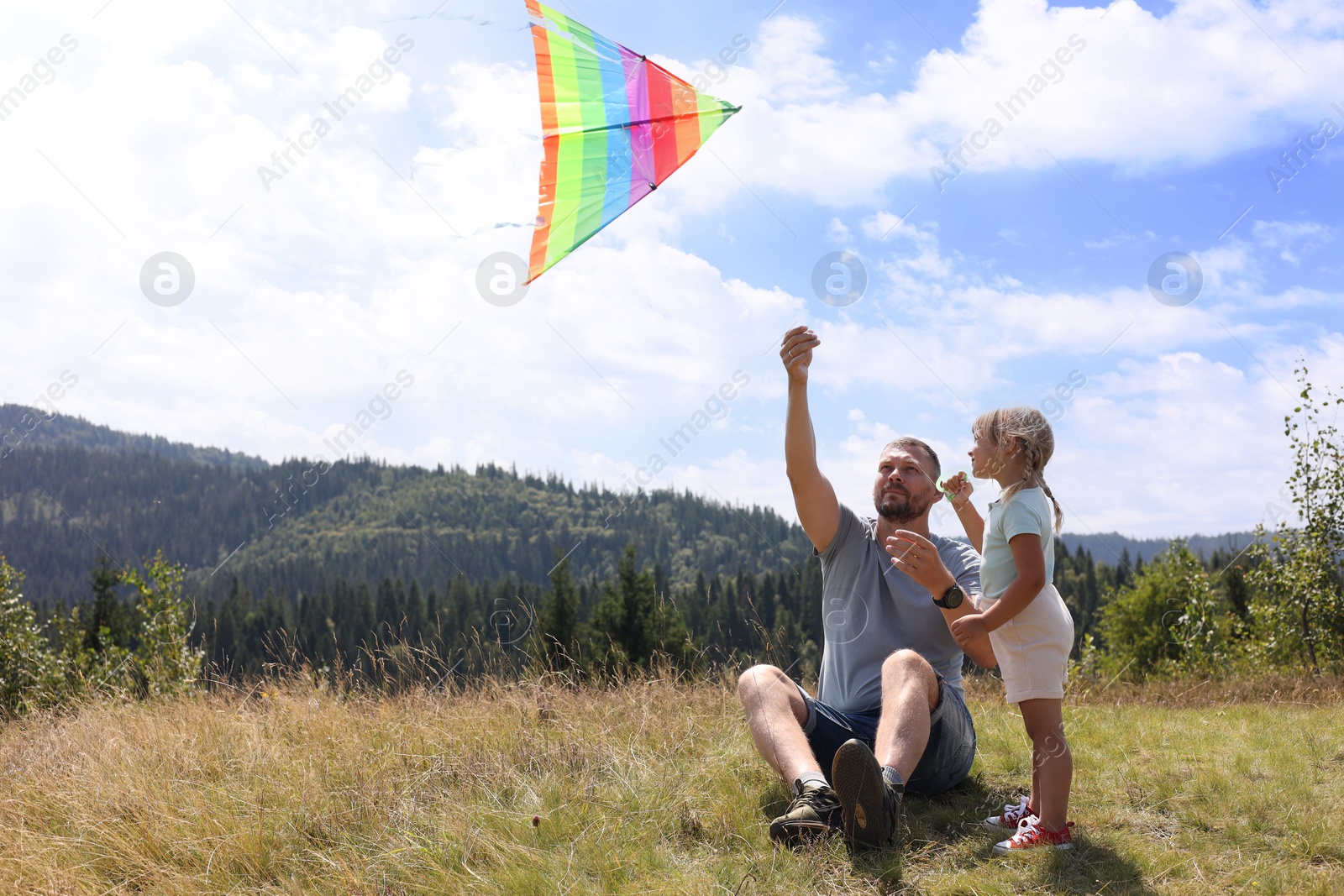 Photo of Father with daughter flying kite at field