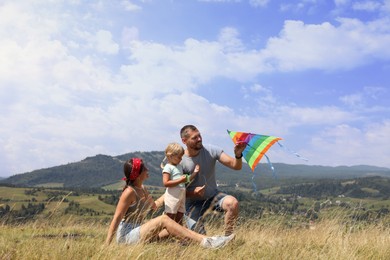 Photo of Happy family flying kite at field under blue sky