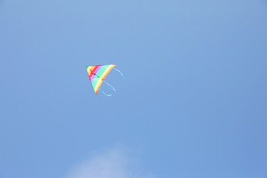 One colorful kite flying in blue sky. Space for text