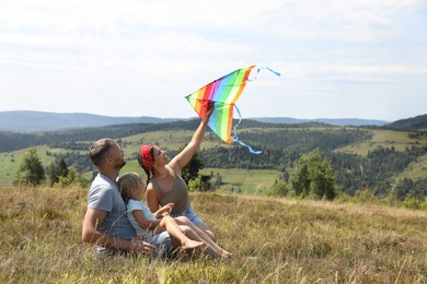 Photo of Happy family flying kite at field under blue sky