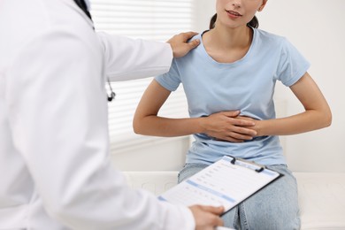 Photo of Doctor consulting patient with stomach pain in clinic, closeup