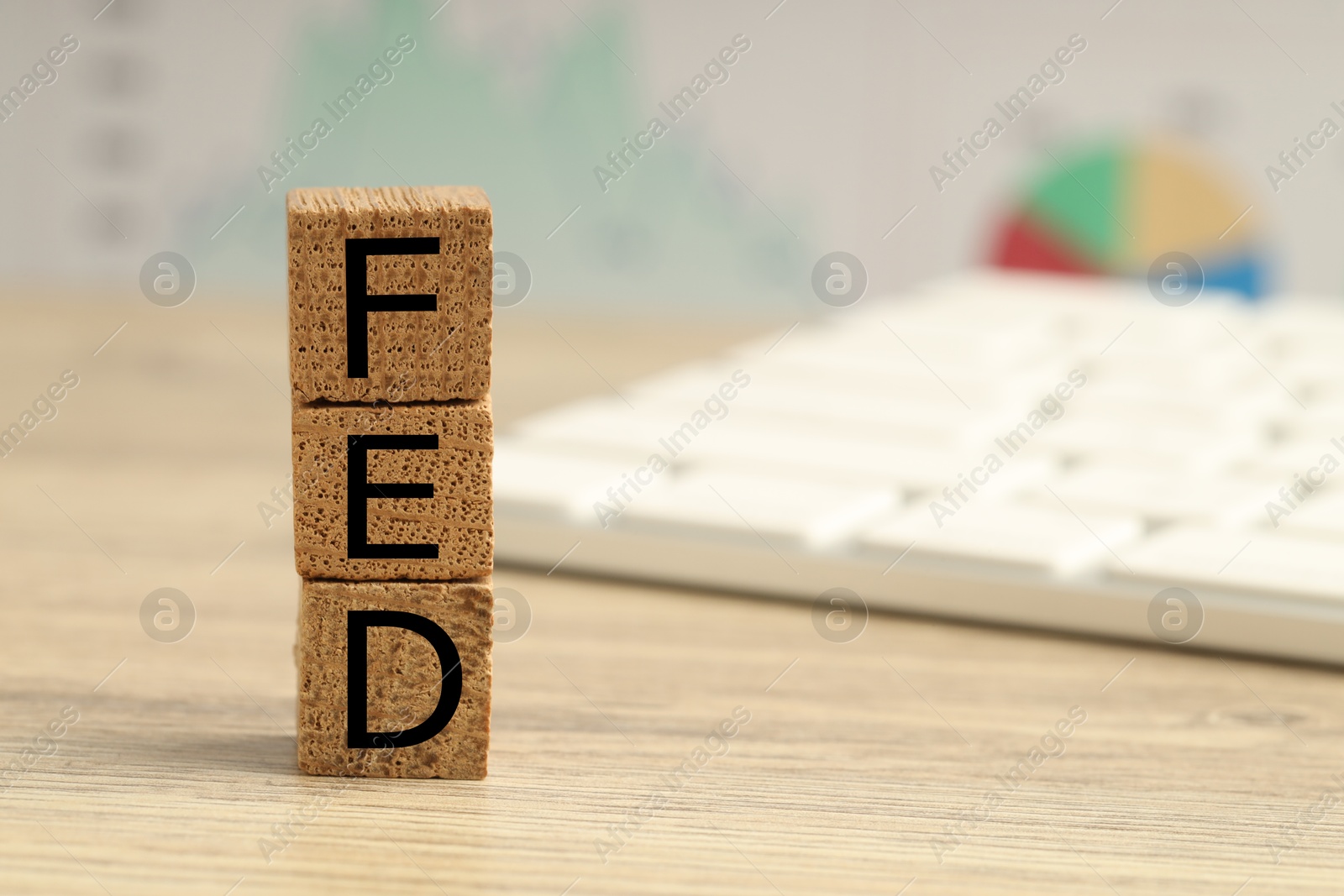 Photo of Cubes with letters Fed (Federal Reserve System) on wooden table, closeup. Space for text