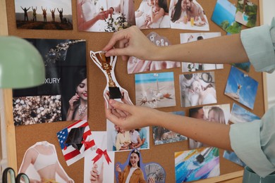 Photo of Woman creating vision board with different photos and other elements, closeup