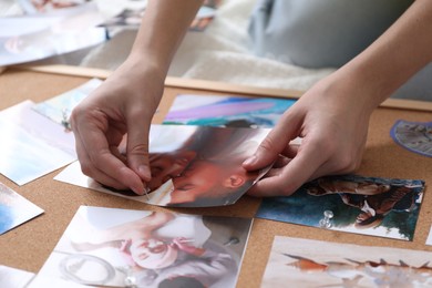 Woman creating vision board with different photos and other elements on bed indoors, closeup