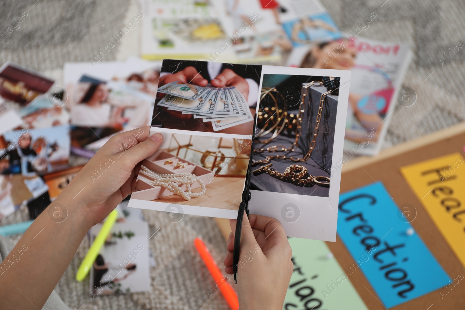 Photo of Creating vision board. Woman cutting out picture on floor indoors, closeup