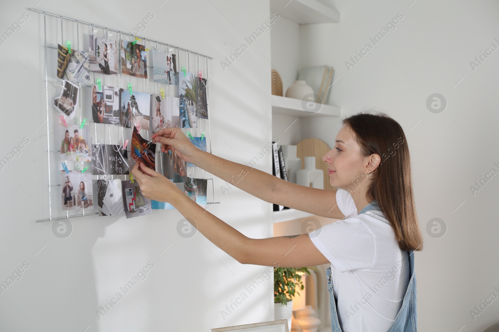 Photo of Woman creating vision board with different photos indoors