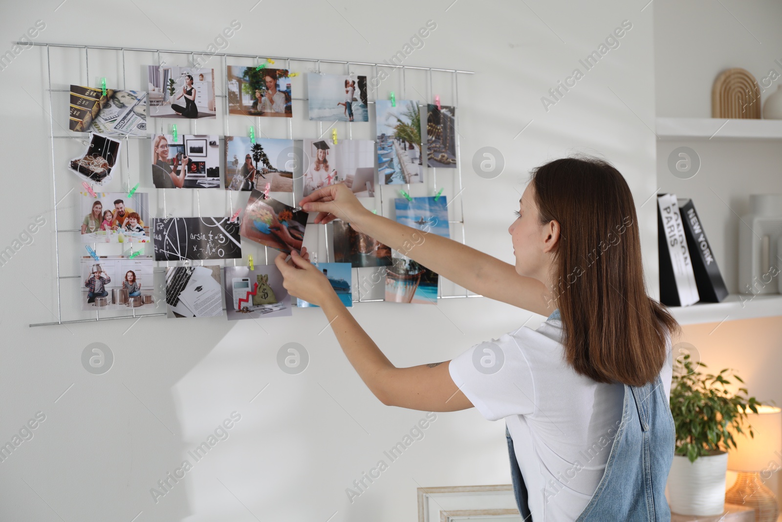 Photo of Woman creating vision board with different photos indoors