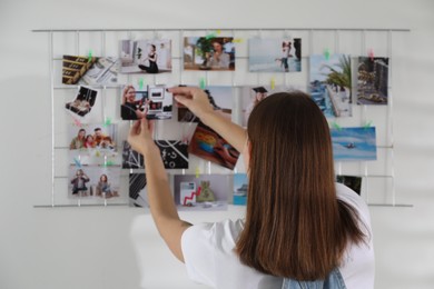 Photo of Woman creating vision board with different photos indoors