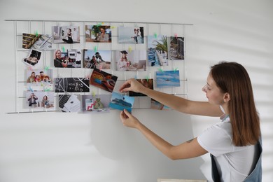 Woman creating vision board with different photos indoors