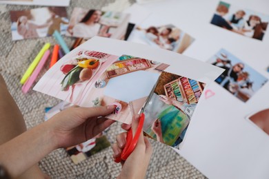 Photo of Creating vision board. Woman cutting out picture on floor indoors, closeup