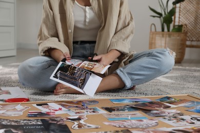 Creating vision board. Woman cutting out picture on floor indoors, closeup