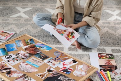 Photo of Creating vision board. Woman cutting out picture on floor indoors, closeup