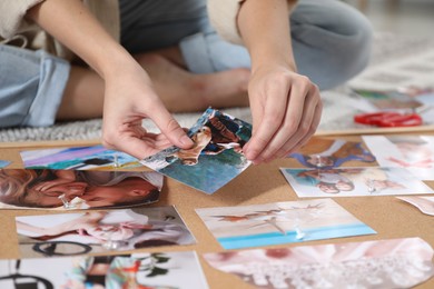 Photo of Woman creating vision board with different photos and other elements on floor indoors, closeup