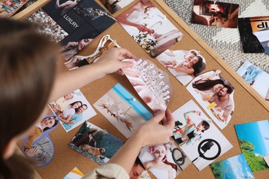 Woman creating vision board with different photos and other elements on floor indoors, closeup