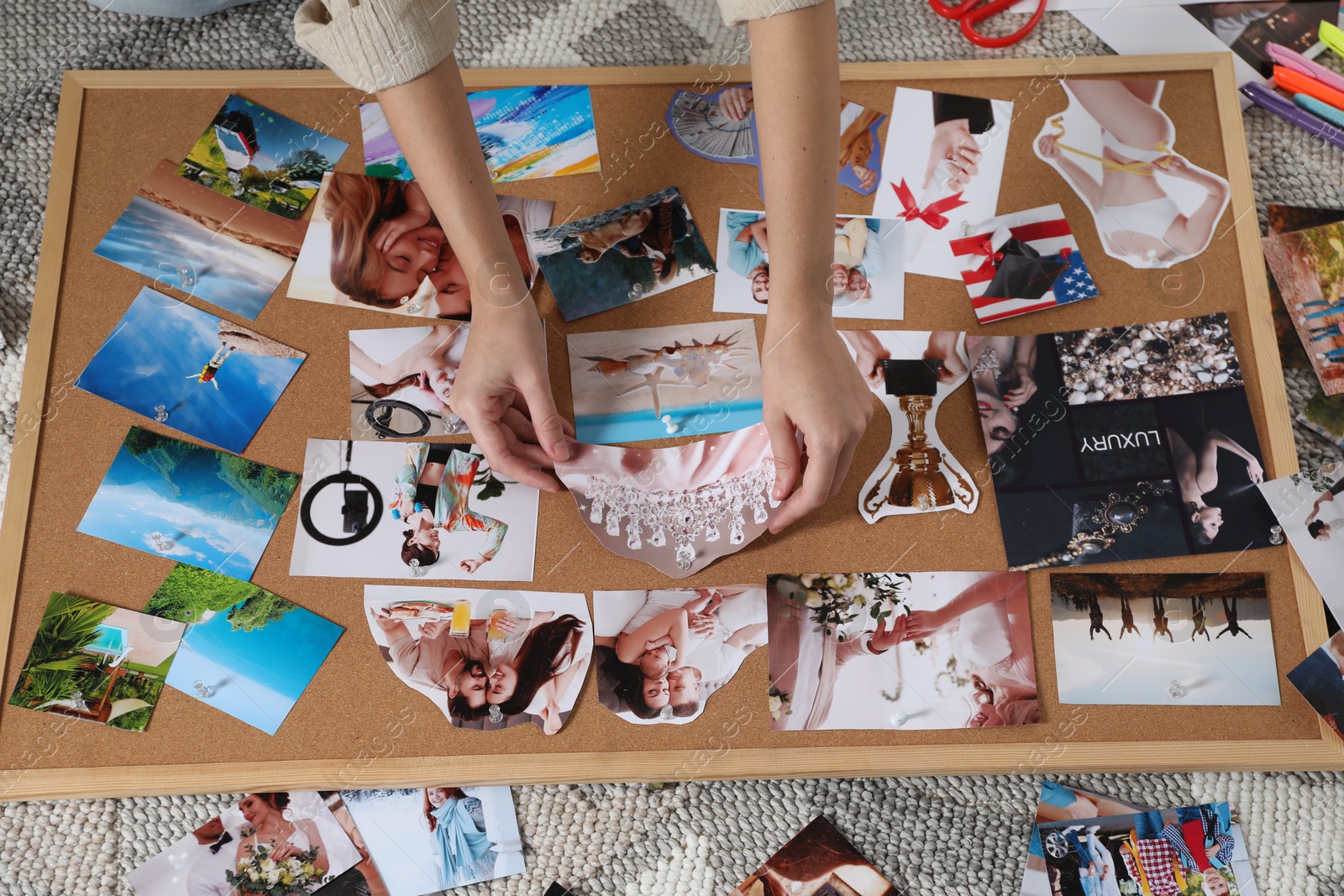 Photo of Woman creating vision board with different photos and other elements on floor indoors, closeup