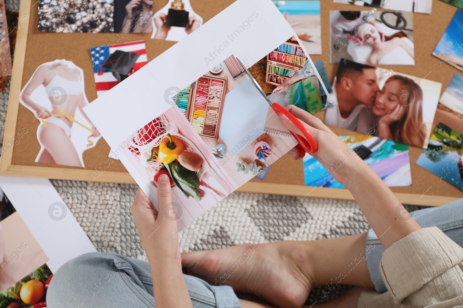 Photo of Creating vision board. Woman cutting out picture on floor indoors, top view