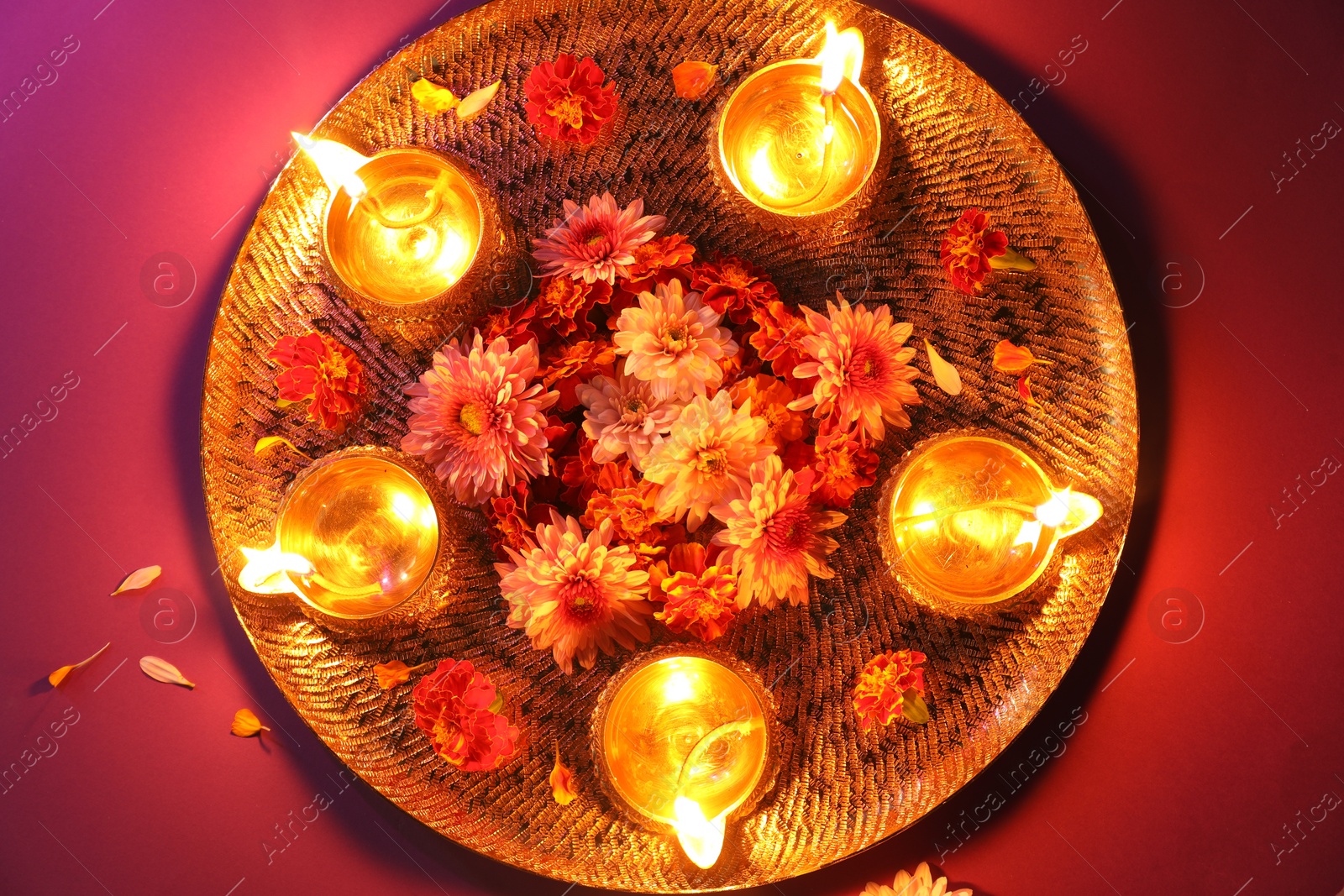 Photo of Diwali celebration. Diya lamps and beautiful flowers on color background, top view