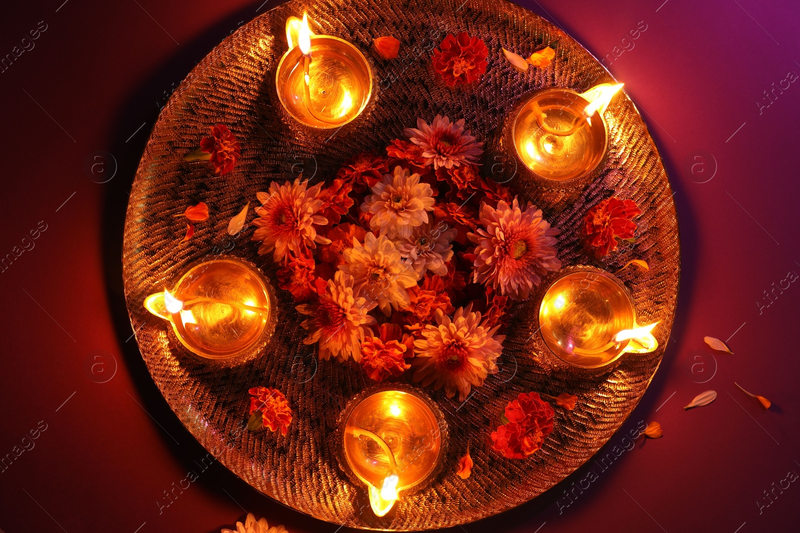 Photo of Diwali celebration. Diya lamps and beautiful flowers on color background, top view