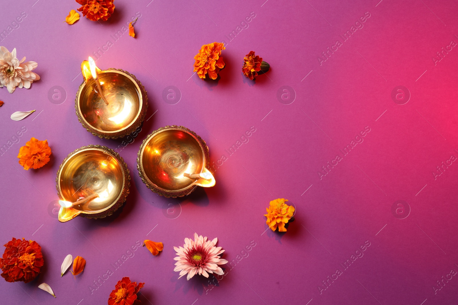 Photo of Diwali celebration. Diya lamps and beautiful flowers on color background, flat lay. Space for text