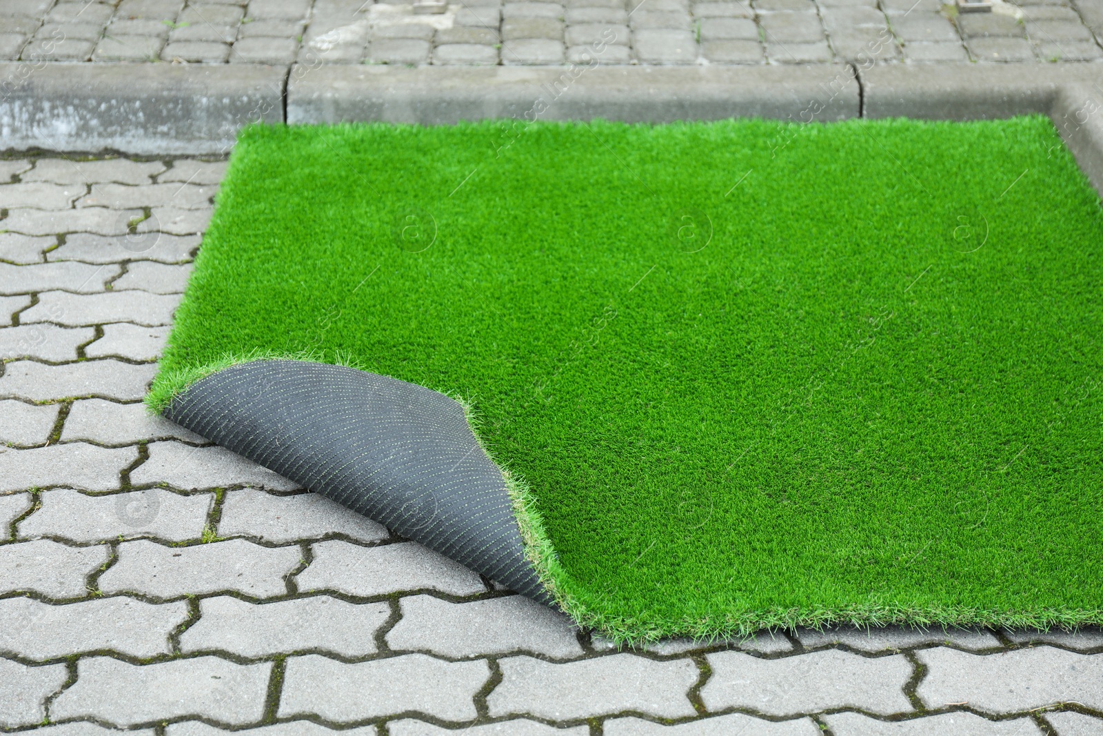 Photo of Sheet of green artificial turf in yard