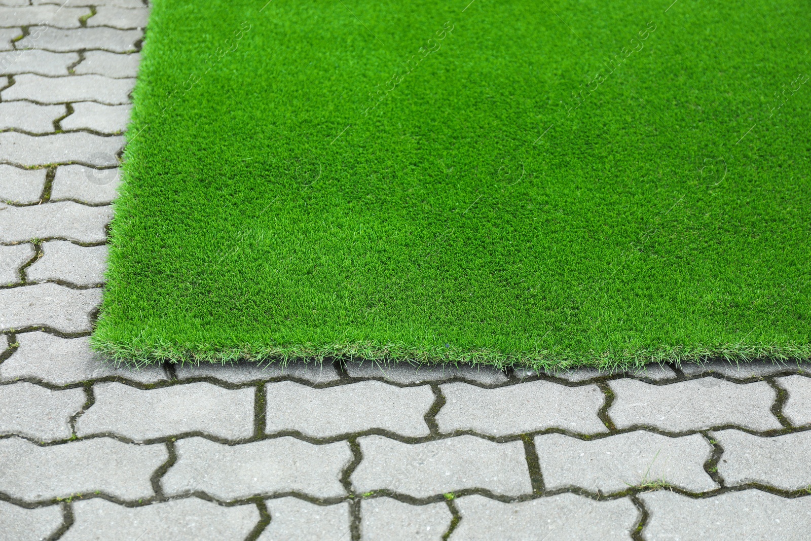 Photo of Sheet of green artificial turf in yard