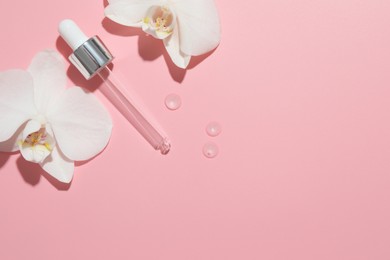 Beautiful orchid flowers and dropper with cosmetic product in water on pink background, flat lay. Space for text