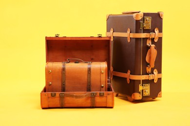 Photo of Three different brown suitcases on yellow background