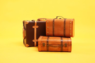 Photo of Three different closed suitcases on yellow background