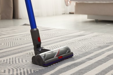 Photo of Cleaning with wireless handheld vacuum cleaner indoors, closeup