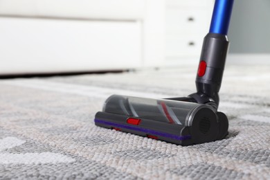 Photo of Cleaning with wireless vacuum cleaner at home, closeup. Space for text