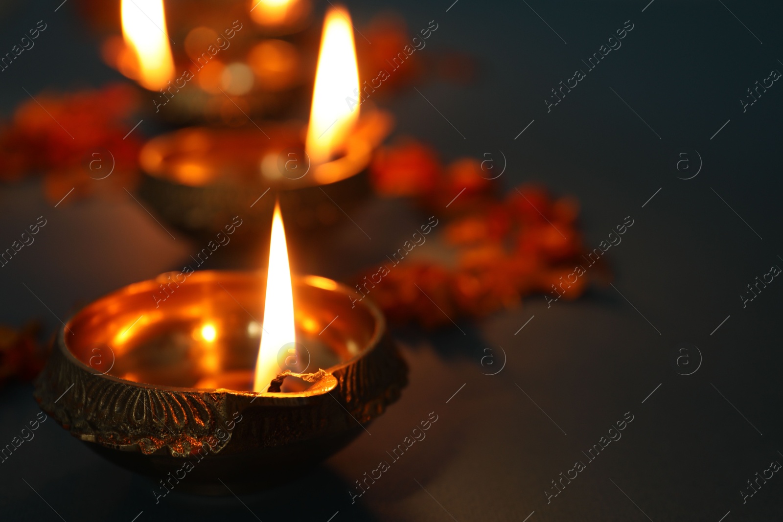 Photo of Diwali celebration. Diya lamps dark background, closeup. Space for text