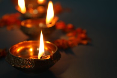 Photo of Diwali celebration. Diya lamps dark background, closeup. Space for text