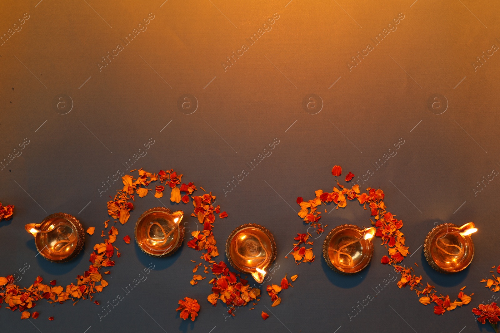 Photo of Diwali celebration. Diya lamps and beautiful flowers on color background, flat lay. Space for text