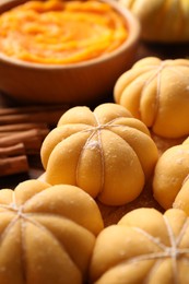 Photo of Raw pumpkin shaped buns and ingredients on table, closeup