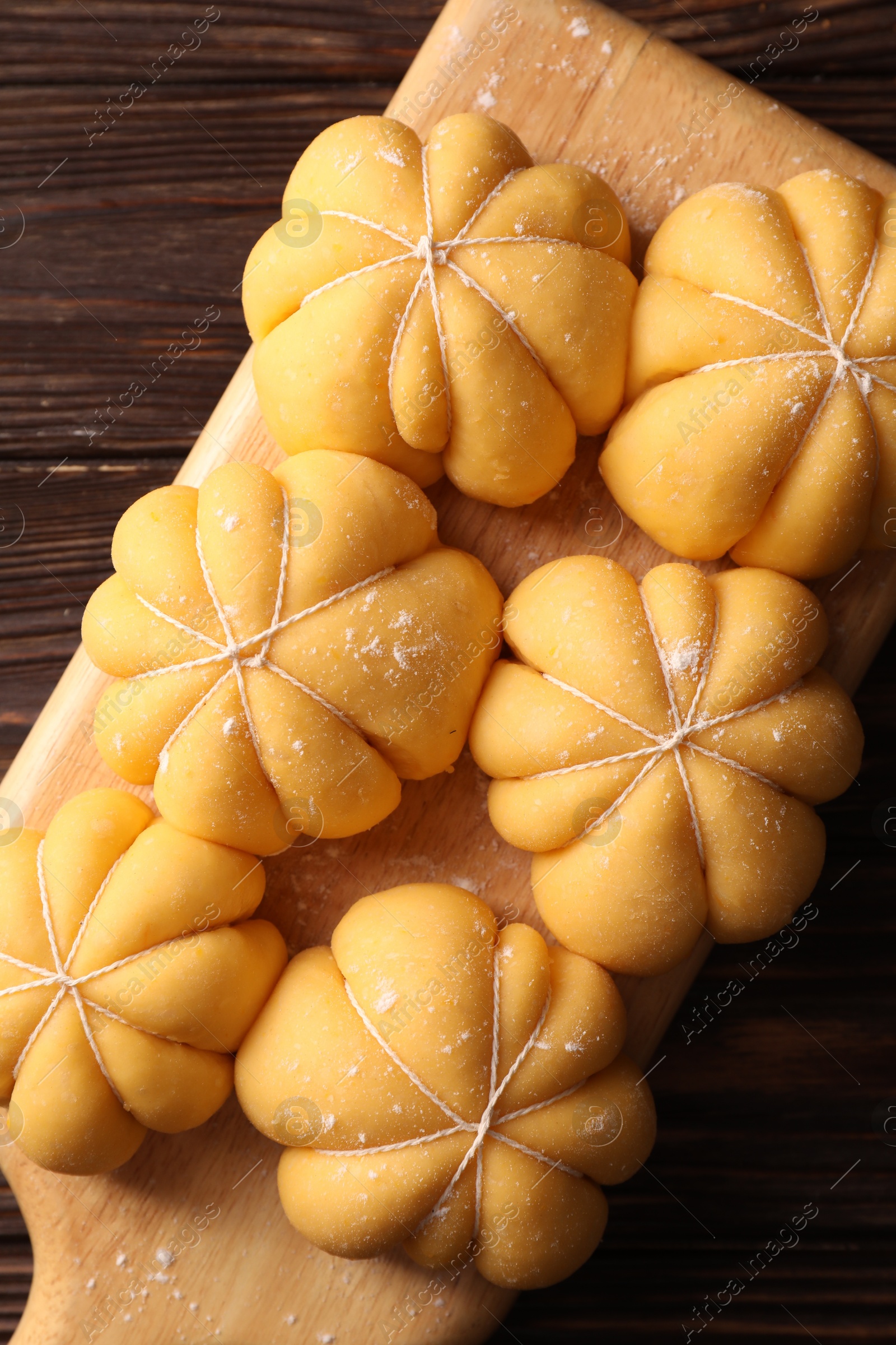 Photo of Raw pumpkin shaped buns on wooden table, top view