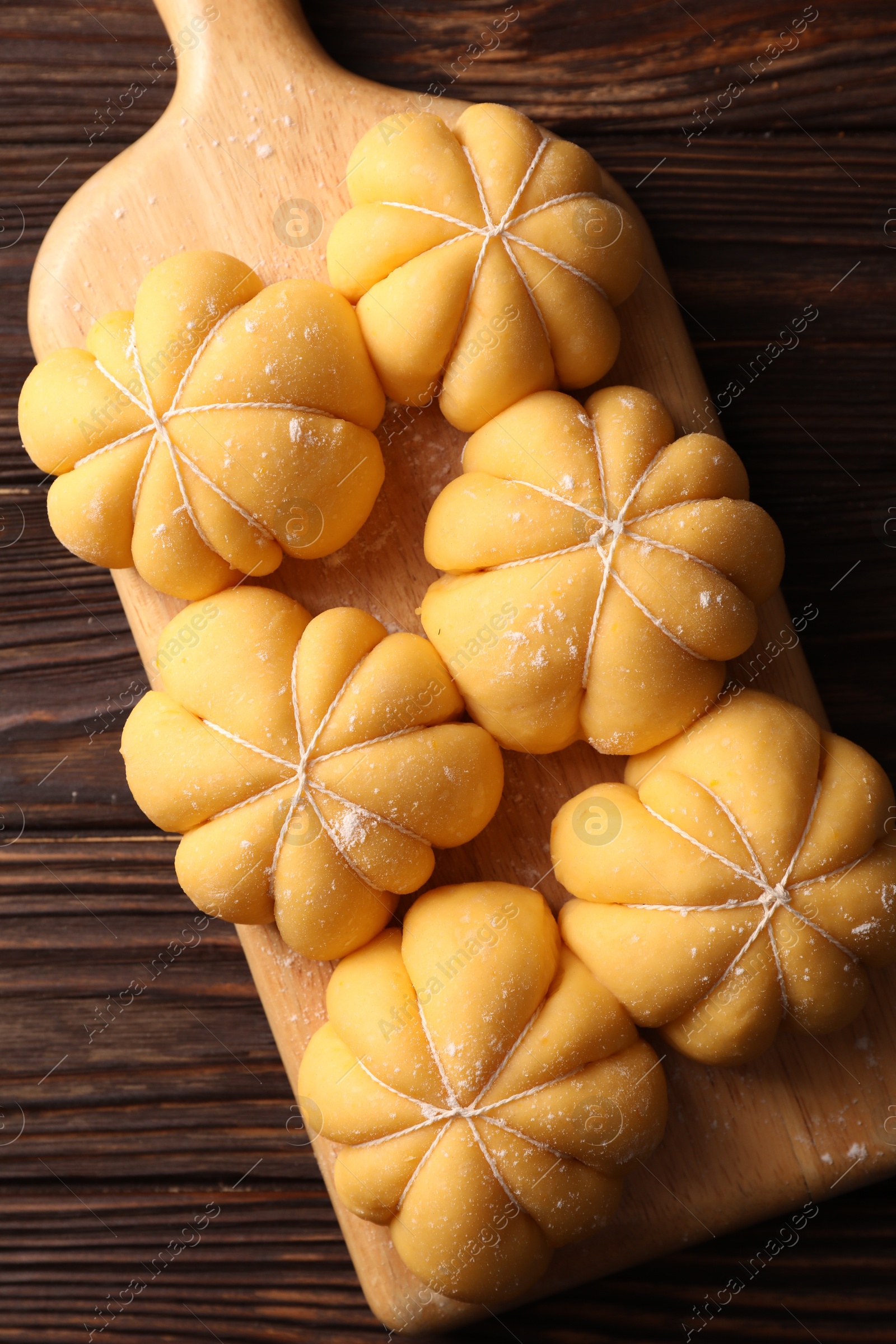 Photo of Raw pumpkin shaped buns on wooden table, top view