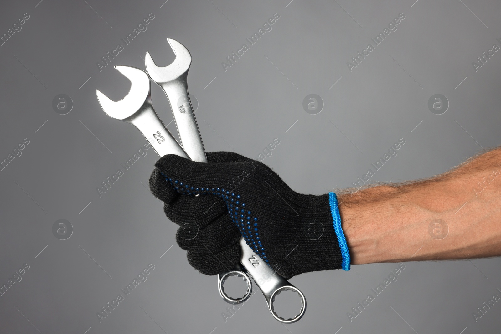 Photo of Auto mechanic with wrenches on grey background, closeup