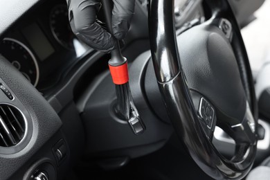 Man cleaning car interior with brush, closeup