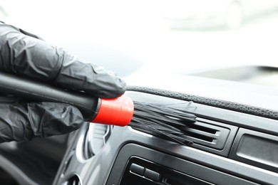 Man cleaning car interior with brush, closeup