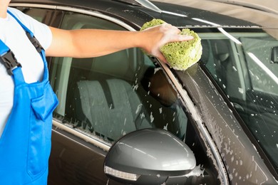 Man washing auto with sponge at car wash, closeup