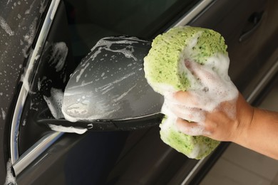 Man washing auto with sponge at car wash, closeup