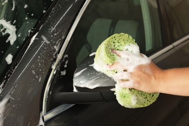 Man washing auto with sponge at car wash, closeup