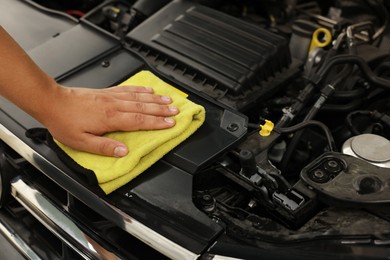 Photo of Man wiping auto engine with rag at car wash, closeup