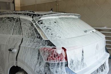 Auto covered with cleaning foam at car wash