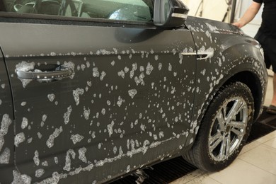 Photo of Auto covered with cleaning foam at car wash, closeup