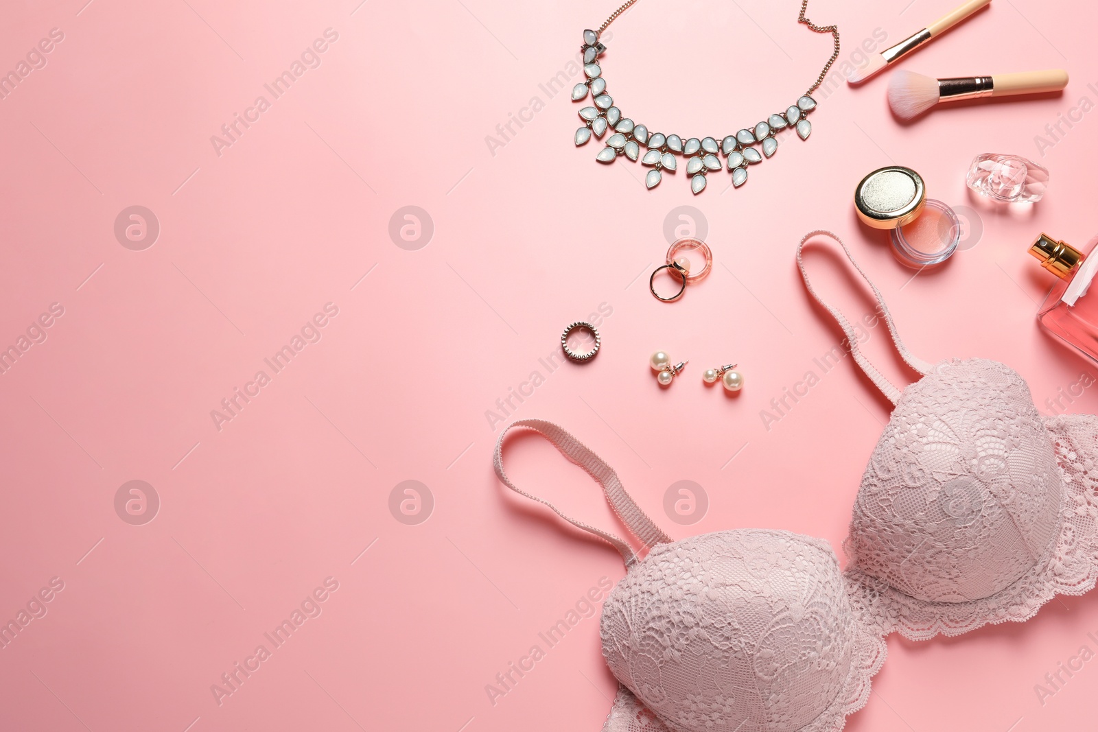 Photo of Elegant lace women's underwear, jewellery, cosmetics and perfume on pink background, flat lay. Space for text